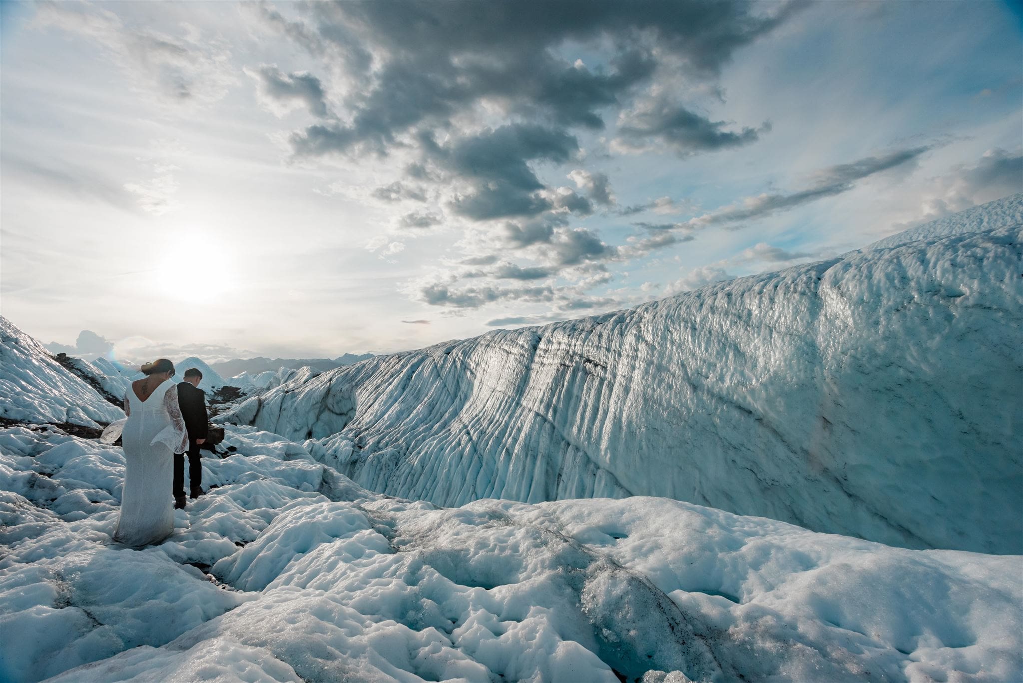 This is a picture of a bride and groom exploring icebergs during their elopement experience.