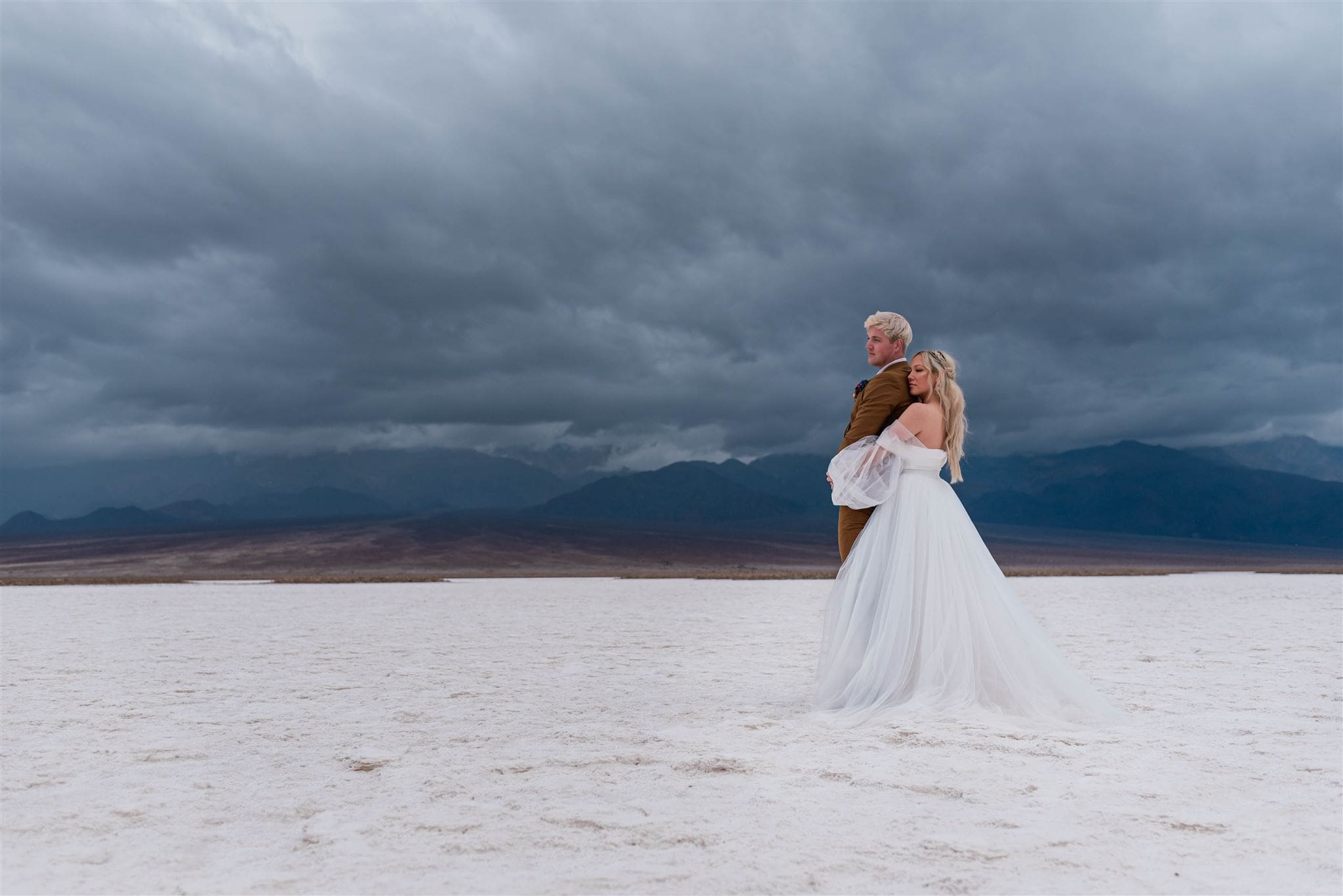 This is a picture of a bride and groom saying their vows on the salt flats. They are all alone and enjoying their solitude time together.