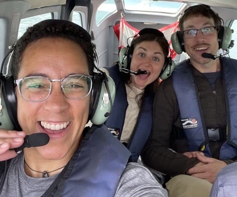 Alaska elopement photographer and planner Kate Okenatez-Mahoney, smiles with a couple as they take off in a float plane elopement experience near Lake Clark National Park in Alaska.