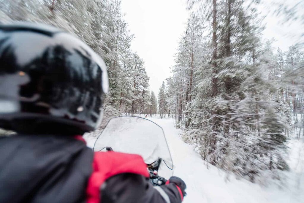 Snowmobiling near Fairbanks to inspire ways to elope in Alaska in the winter that are unique and beautiful with the snow covered trees whizzing by