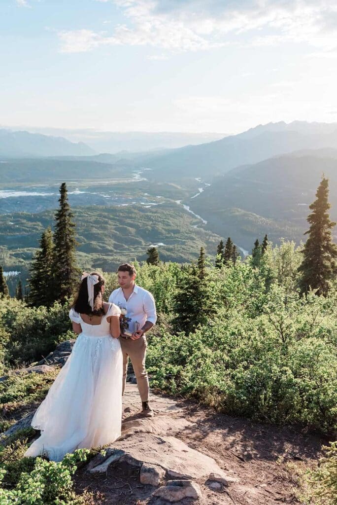 Hiking near Alpenglow glamping during a Matanuska Glacier wedding experience gives sweeping mountain views as a way to elope in Alaska in the summer's midnight sun
